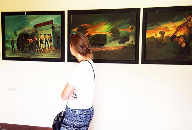 Du khách xem những bức tranh tái hiện cảnh tra tấn tại “Cánh đồng chết”. Du khách xem những bức tranh tái hiện cảnh tra tấn tại “Cánh đồng chết”.