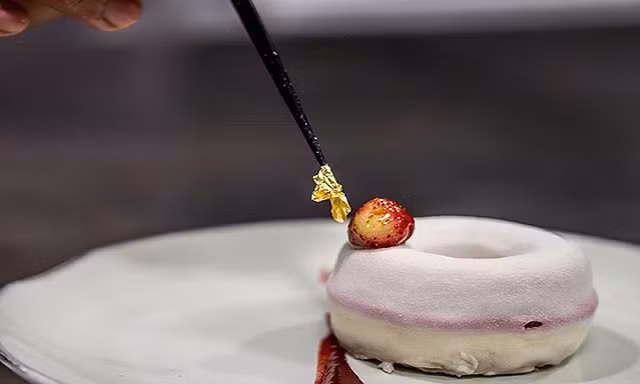 Bánh phô mai dạng bánh vòng cỡ lớn trang trí lá vàng.