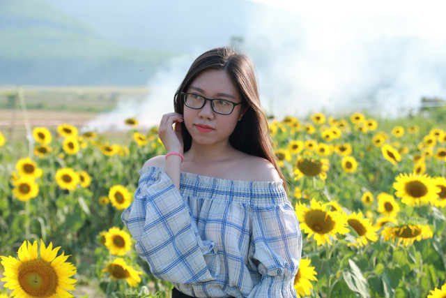 Một thiếu nữ tạo dáng bên hoa hướng dương