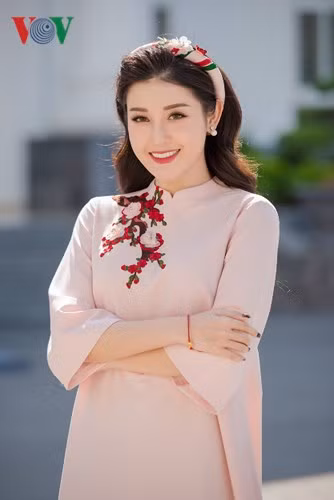 Á hậu Việt Nam 2014 khoe vẻ dịu dàng trong bộ áo dài màu hồng nhạt. 