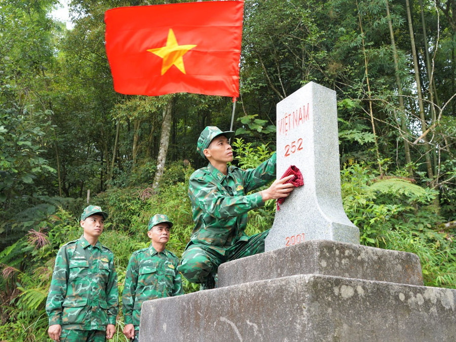 Trung úy Phàn Thế Sơn, cán bộ Đồn biên phòng Cửa khẩu quốc tế Thanh Thủy, kiểm tra, lau mốc 252 trên điểm cao 1509. Ảnh: M.T.H - N.Đ.L