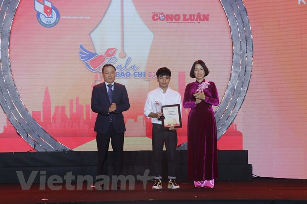 Bà Vũ Việt Trang, Bí thư Đảng ủy, Tổng Giám đốc Thông tấn xã Việt Nam (phải) và ông Nguyễn Đức Lợi, Phó Chủ tịch Thường trực Hội Nhà báo Việt Nam (trái) trao giải A cho tác giả Đinh Đức Long (Báo Dân Trí). (Ảnh: Việt Anh/Vietnam+)