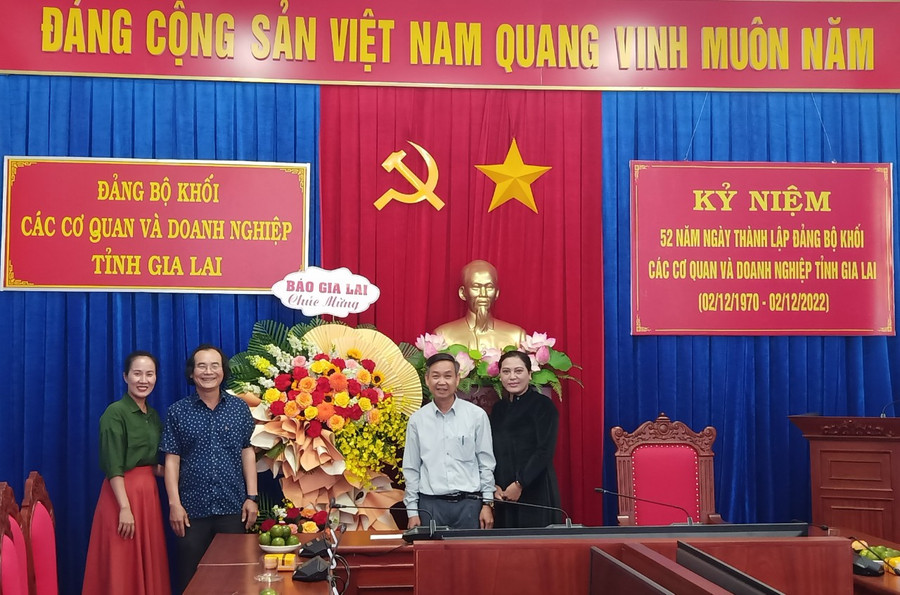 Phó Bí thư Đảng ủy, Phó Tổng Biên tập Báo Gia Lai Khuất Đình Viện (thứ 2 từ trái qua) tặng hoa chúc mừng tập thể lãnh đạo, cán bộ, đảng viên của Đảng ủy Khối các Cơ quan và Doanh nghiệp tỉnh. Ảnh: Đoàn Nga Ảnh: Đoàn Nga