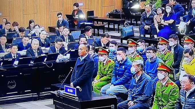 Bị cáo Trần Đình Thành trước bục khai báo. Ảnh chụp màn hình Bị cáo Trần Đình Thành trước bục khai báo. Ảnh chụp màn hình