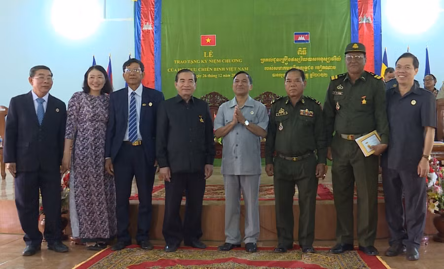 Ông Nay Hứ (thứ 5, từ trái qua) và đoàn công tác trao kỷ niệm chương cho các đại biểu tỉnh Ratanakiri