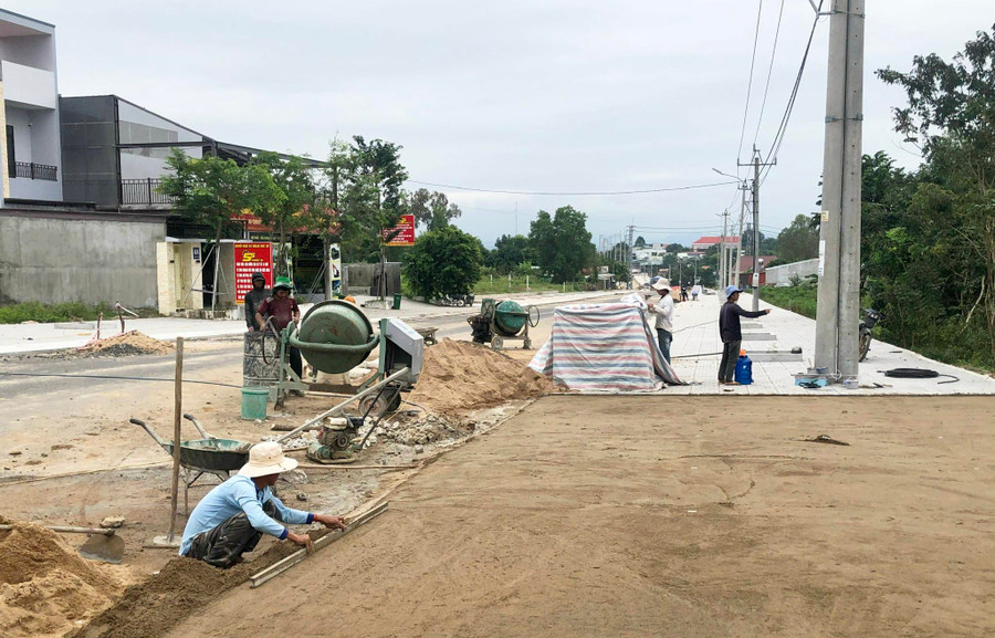 Công nhân thi công ốp lát vỉa hè đường Trần Phú, thị trấn Phú Túc, huyện Krông Pa. Ảnh: Gia Hưng