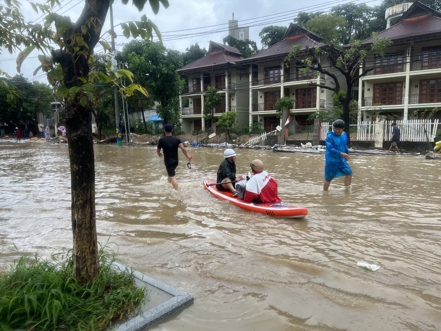  Nhiều người phải dùng xuồng để di chuyển qua khu vực ngập sâu. Ảnh: Hoài Luân 
