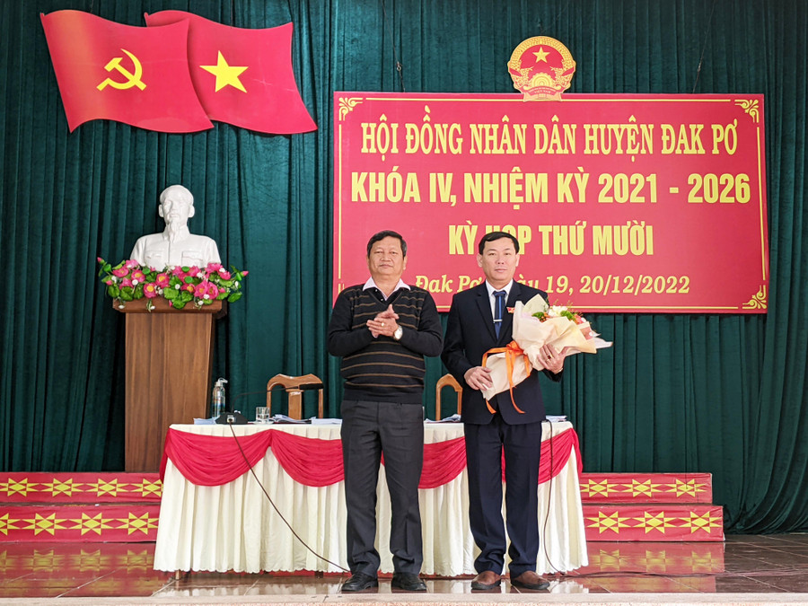 Ông Ngô Khắc Ngọc, Tỉnh ủy viên, Hiệu trường Trường Chính trị tỉnh tặng hoa chúc mừng ông Bùi Văn Khánh. Ảnh: Nguyễn Hiền