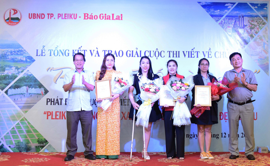 Ông Trần Xuân Quang (bìa trái)-Phó Bí thư Thường trực Thành ủy Pleiku và Tổng Biên tập Báo Gia Lai Huỳnh Kiên (bìa phải) trao giải nhất cho các tác giả, nhóm tác giả đạt giải. Ảnh Đức Thụy