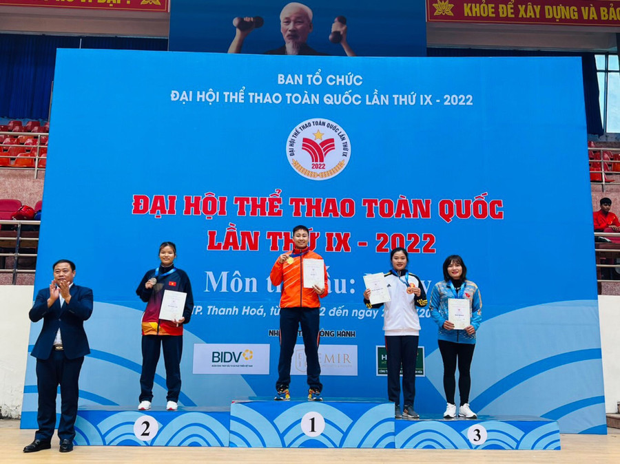 Võ sĩ Phạm Thị Xoan (bìa phải) nhận tấm huy chương đồng môn Muay. Ảnh: Văn Hường