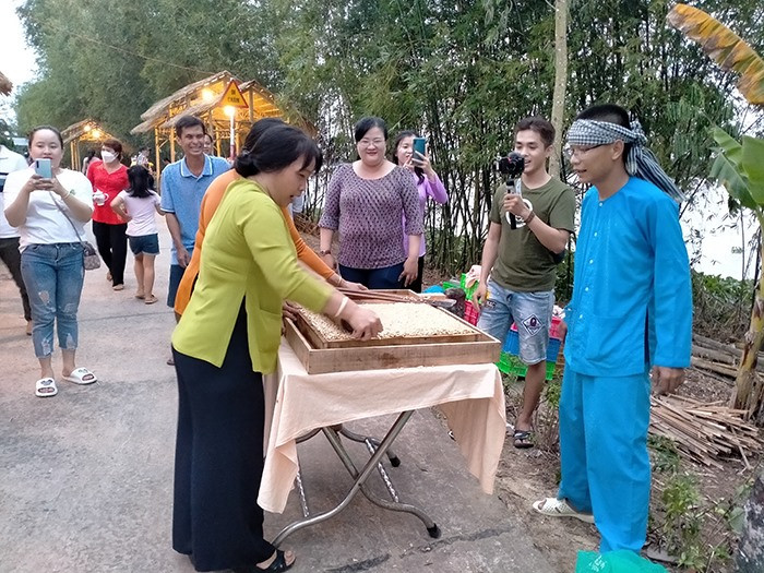 Du khách thích thú trải nghiệm làm bánh tại chợ. Ảnh: Cổng TTĐT tỉnh Đồng Tháp