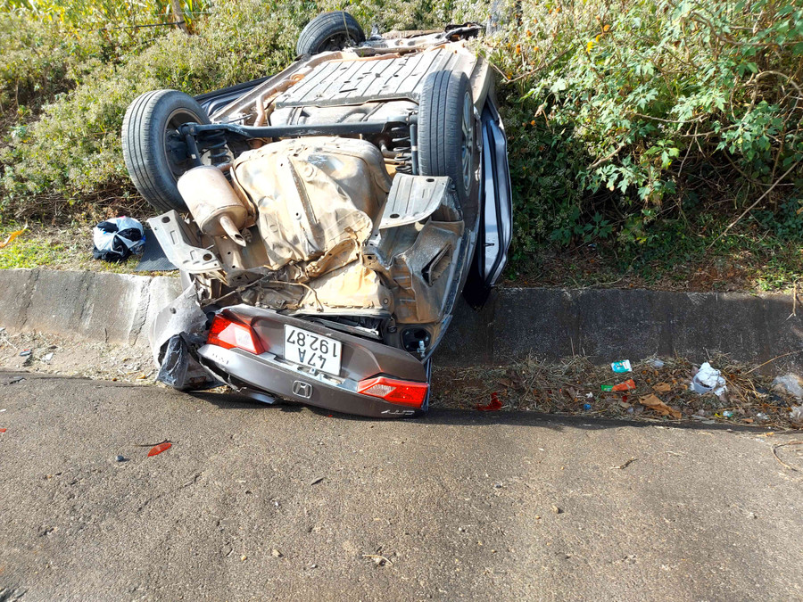 Ô tô BKS 47A-192.87 bị lật úp bên vệ đường sau va chạm. Ảnh: Thiên Di