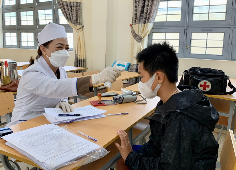 Nhân viên y tế phường Hội Thương, TP. Pleiku khám sàng lọc trước khi tiêm vắc xin phòng Covid-19 cho trẻ. Ảnh Như Nguyện