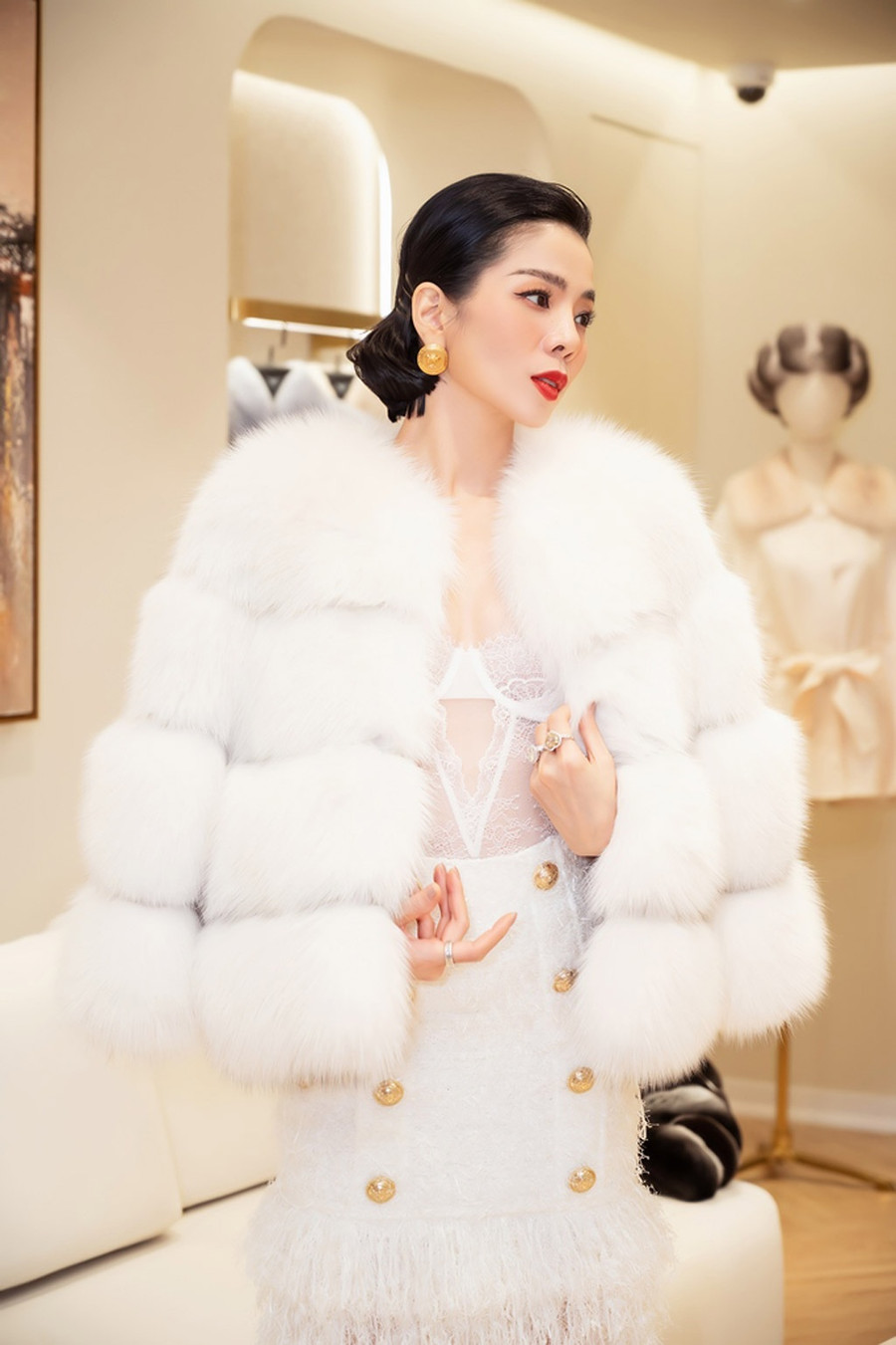 Bước xuống từ xe sang, Lệ Quyên diện cả cây trắng sành điệu. Cô phối bộ cánh cùng áo corset ren gợi cảm bên trong và đi boots da trắng cao cổ, vừa đảm bảo giữ ấm cơ thể giữa mùa đông Hà Nội vừa tôn lên nét gợi cảm. Ảnh: Trương Gia Huy