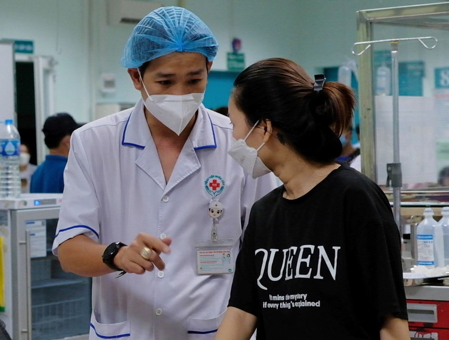 Điều dưỡng Nguyễn Quốc Thư giải thích bệnh cho người nhà bệnh nhân.