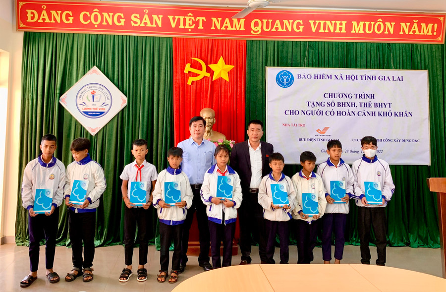 Phó Giám đốc BHXH tỉnh Gia Lai Trần Ngọc Tuấn (áo xanh) và đại diện chính quyền địa phương trao tặng thẻ BHYT cho học sinh tại Trường THCS Lương Thế Vinh, xã Chư Á, TP. Pleiku. Ảnh: Như Nguyện