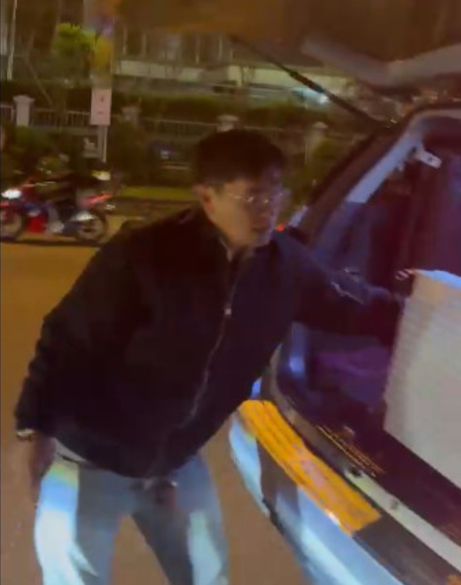 Tài xế taxi mở cốp xe ô tô quăng hành lý của du khách xuống đường. Ảnh chụp lại từ clip Tài xế taxi mở cốp xe ô tô quăng hành lý của du khách xuống đường. Ảnh chụp lại từ clip