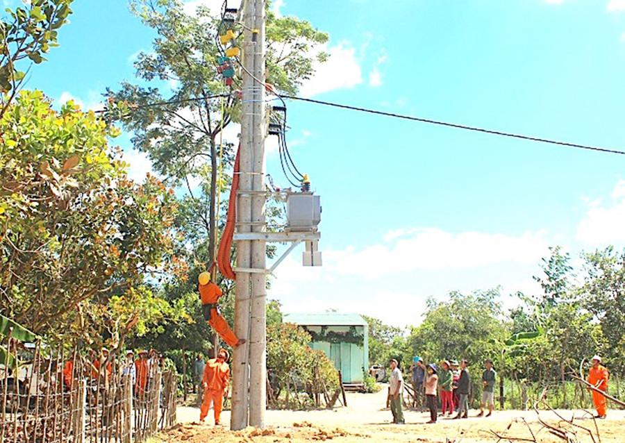  Công nhân Điện lực Đức Cơ đóng điện tại làng Nan, xã Ia Nan. Ảnh: Khang Nghi