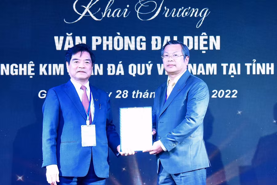 Nhà báo, Tiến sĩ Lê Ngọc Dũng (bìa trái)-Chủ tịch Hội Mỹ nghệ kim hoàn đá quý Việt Nam trao quyết định thành lập Văn phòng đại diện Hội tại Gia Lai cho Nghệ nhân Hoàng Ngọc Minh-Giám đốc Doanh nghiệp tư nhân Hiệu vàng Vĩnh Thạnh 2 (TP. Pleiku). Ảnh: Đức Thụy