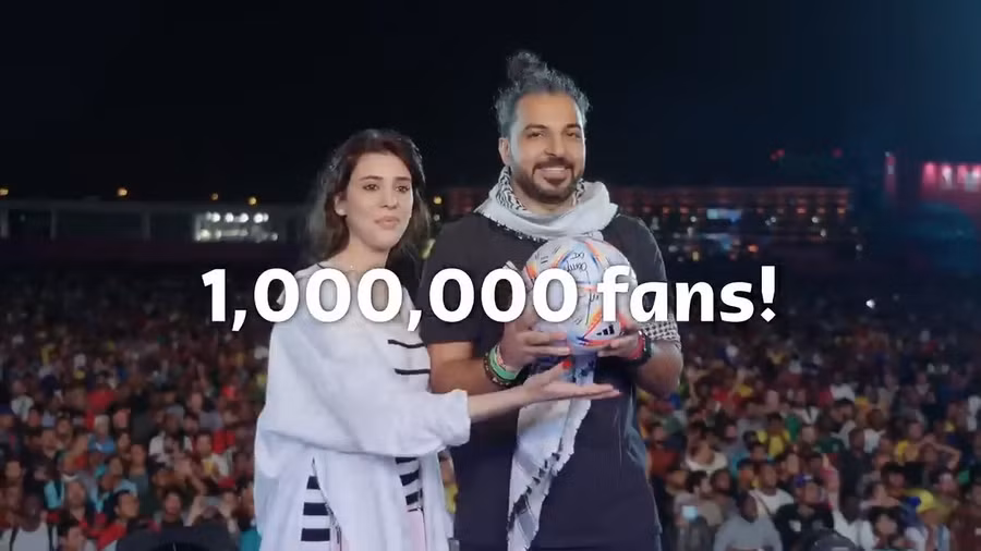  Haytham và Sarah (trái) nhận quả bóng có chữ ký của hai danh thủ bóng đá, và một cặp vé xem chung kết FIFA World Cup 2022. Ảnh: FIFA 