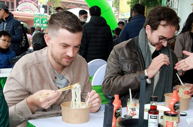 Du khách nước ngoài thưởng thức món phở. Ảnh: Văn Đạt/TTXVN