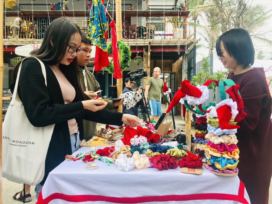 Du khách tìm hiểu các sản phẩm tái chế thân thiện với môi trường. Ảnh: Q.T/ Báo Quảng Nam