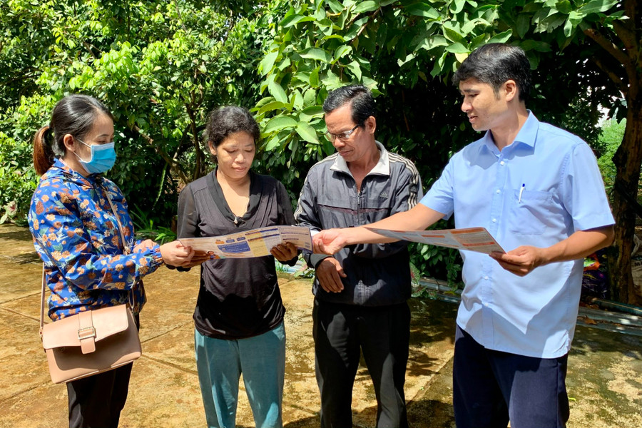 Cán bộ BHXH huyện Ia Grai tuyên truyền người dân tham gia BHYT. Ảnh: Như Nguyện