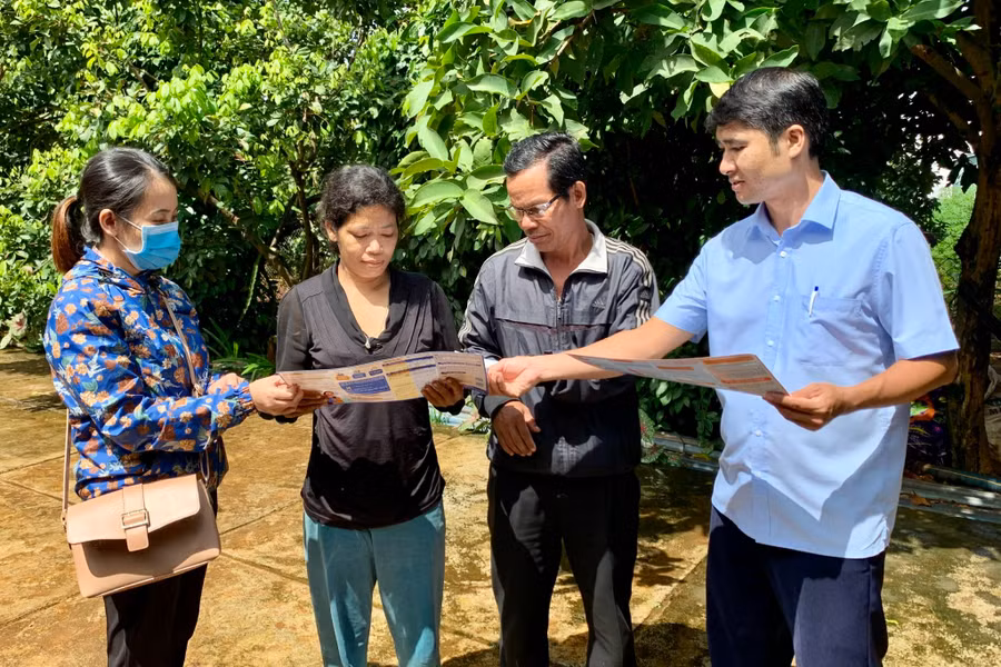 Cán bộ BHXH huyện Ia Grai tuyên truyền người dân tham gia BHYT. Ảnh: Như Nguyện