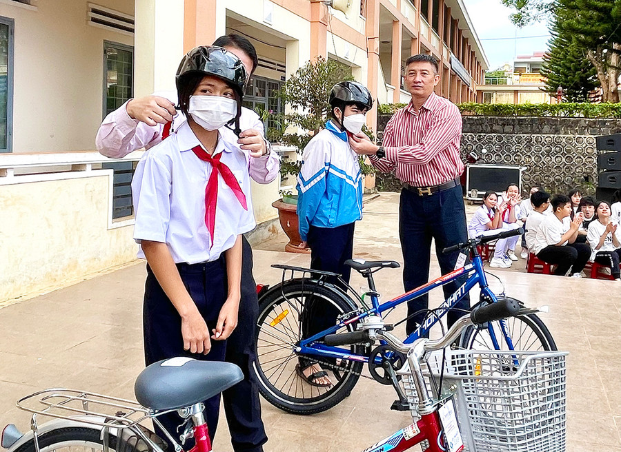 Ông Trần Đình Sơn-Phó Giám đốc Sở Giao thông-Vận tải trao xe đạp và mũ bảo hiểm cho học sinh. Ảnh: Minh Phương