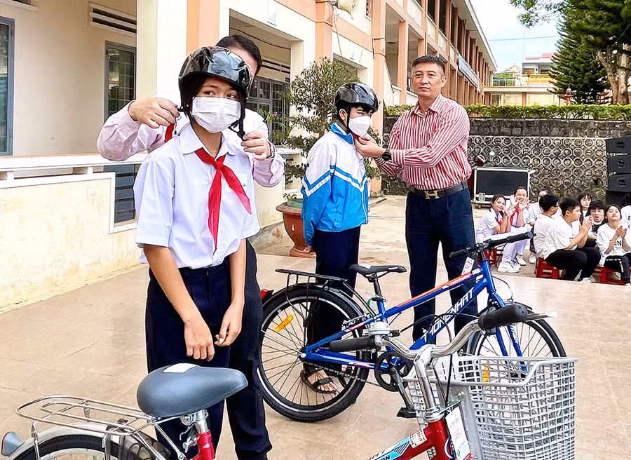 Ông Trần Đình Sơn-Phó Giám đốc Sở Giao thông-Vận tải trao xe đạp và mũ bảo hiểm cho học sinh. Ảnh: Minh Phương
