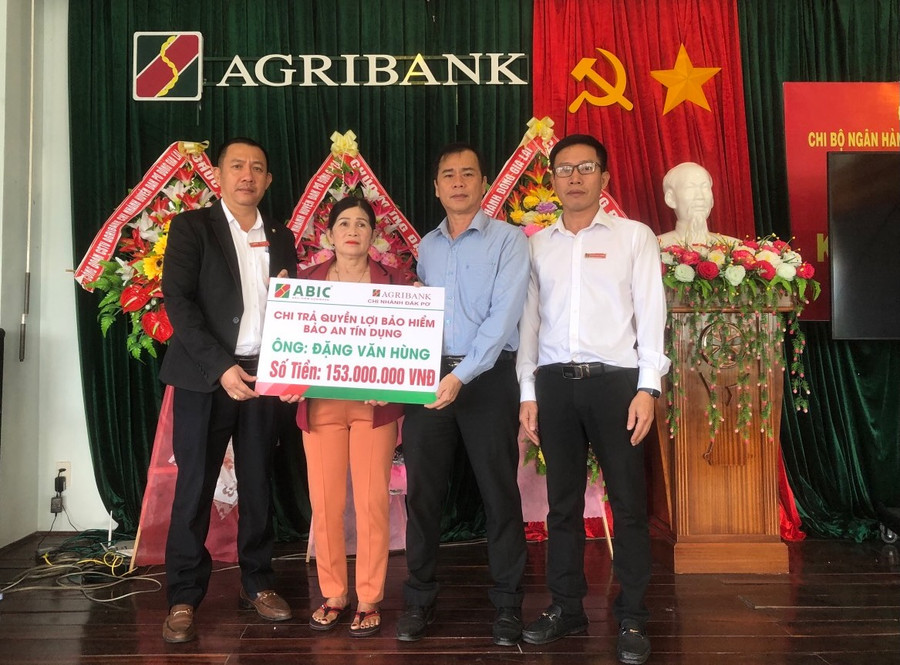 Đại diện ABIC, Agribank Chi nhánh Đak Pơ Đông Gia Lai chi trả quyền lợi bảo hiểm cho gia đình khách hàng Đặng Văn Hùng. Ảnh: Sơn Ca.
