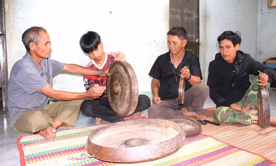  Già làng Đinh Nao (bìa trái, ở làng Hòa Bình, xã Tú An, thị xã An Khê) hướng dẫn cách cầm, diễn tấu cồng chiêng cho thanh niên trong làng. Ảnh: Ngọc Minh