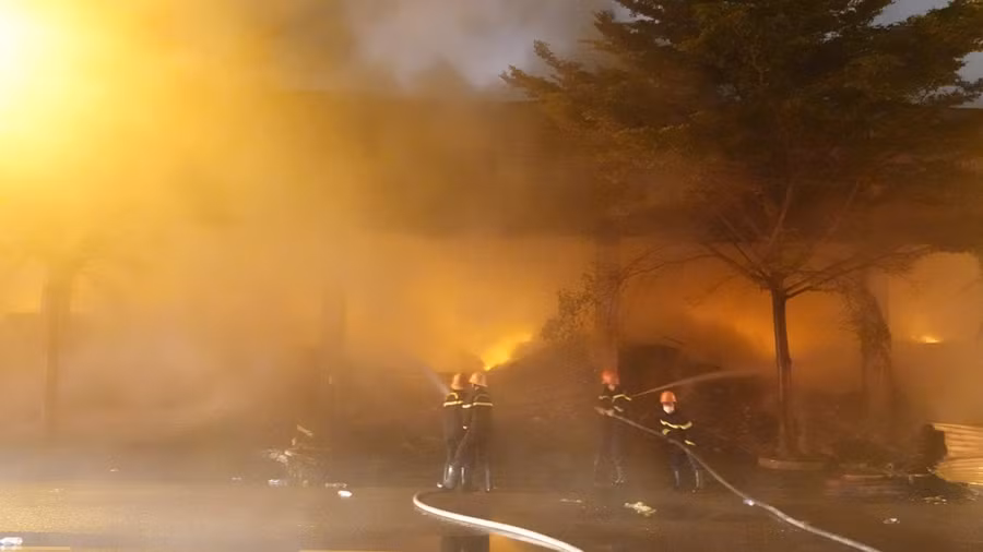 Ngọn lửa âm ỉ bên trong kho hàng rất khó dập tắt. Ảnh: Hoàng Trọng