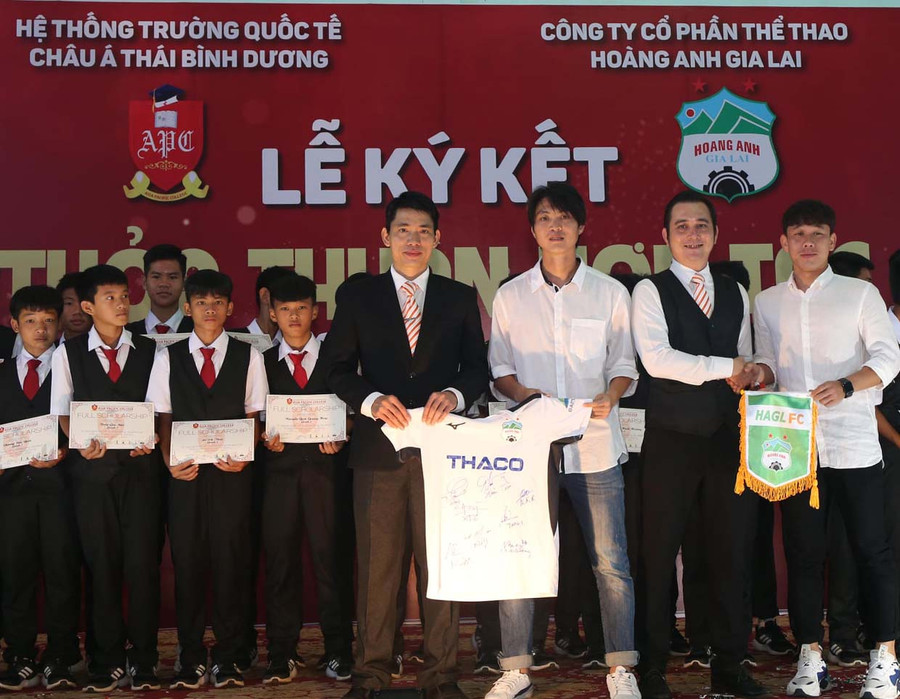  Tiền vệ Nguyễn Tuấn Anh và Trần Minh Vương trao cờ và áo lưu niệm tặng Trường Quốc tế Châu Á Thái Bình Dương- Gia Lai. Ảnh: Minh Trần