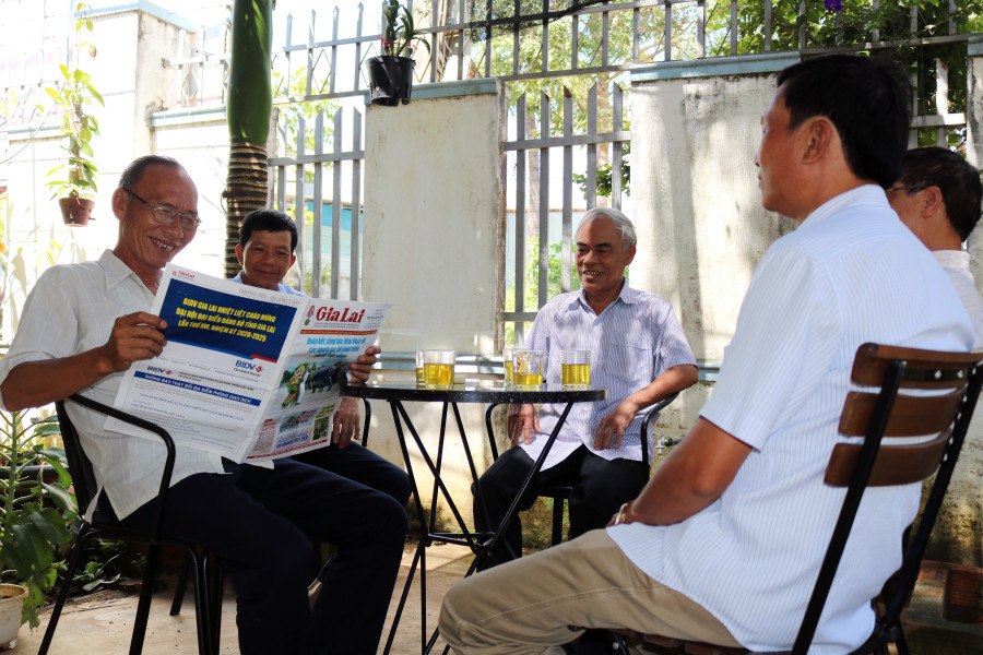 Người dân tổ 4 (phường Thắng Lợi, TP. Pleiku) đọc báo nắm thông tin về Đại hội Đảng bộ tỉnh. Ảnh: Ngọc Sang