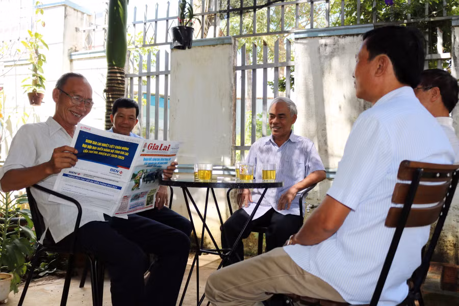 Người dân tổ 4 (phường Thắng Lợi, TP. Pleiku) đọc báo nắm thông tin về Đại hội Đảng bộ tỉnh. Ảnh: Ngọc Sang