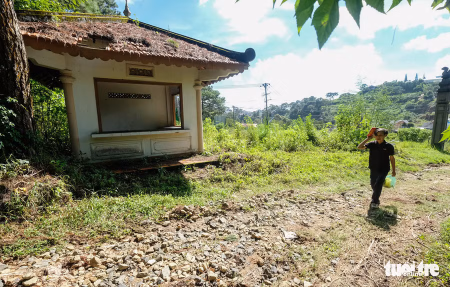  Người tự nhận là bảo vệ khu lăng và cho biết hằng ngày xin tiền du khách để lo nhang đèn thờ tự ở khu lăng mộ - Ảnh: M.VINH