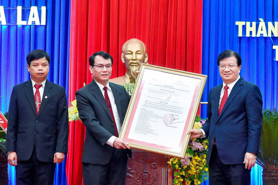 thừa ủy quyền của Thủ tướng Chính phủ, Phó Thủ tướng Chính phủ trịnh Đình Dũng trao Quyết định công nhận TP. Pleiku đạt đô thi loại I. Ảnh: Đức Thủy