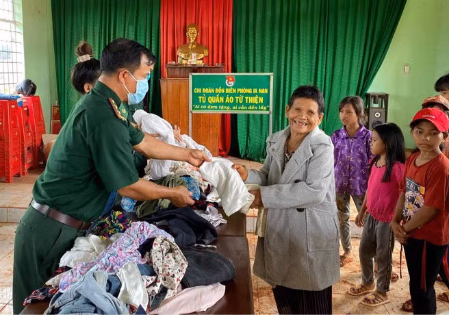 Cán bộ Đồn Biên phòng Ia Nan (huyện Đức Cơ) tặng quần áo cũ cho người dân. Ảnh: Phương Dung