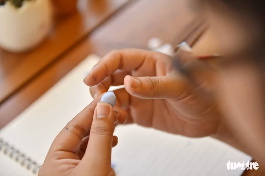 Mỹ Dung cho biết cái khó khi làm sen đá bằng đất sét là tạo cánh cho cây, phải thật tỉ mỉ để kết các cánh đều nhau - Ảnh: NGỌC PHƯỢNG