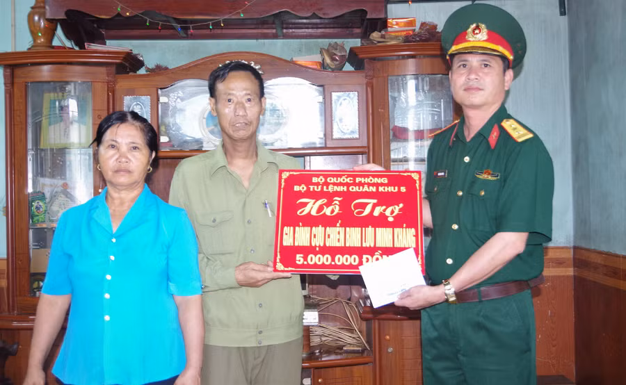 Thượng tá Trần Đình Công – Phó Chủ nhiệm Chính trị Bộ CHQS tỉnh trao tiền hỗ trợ cho gia đình CCB Lưu Minh Kháng. Ảnh: Huy Bắc 