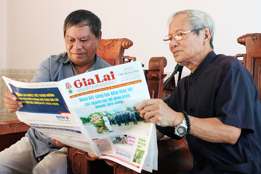 Người dân tổ 6, phường Trà Bá, thành phố Pleiku đọc báo nắm thông tin về Đại hội Đảng bộ tỉnh lần thứ XVI. Ảnh: Ngọc Sang