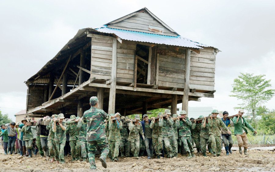 Việc giúp dân di dời nhà ở đã thể hiện sự đồng sức đồng lòng giữa chính quyền, quân và dân trong triển khai thực hiện chủ trương xây dựng làng NTM trong đồng bào dân tộc thiểu số. Ảnh: Minh Nguyễn 