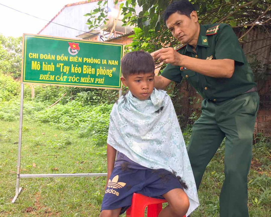 Cán bộ Đồn Biên phòng Ia Nan cắt tóc miễn phí cho các em nhỏ. Ảnh: Phương Dung Các tay kéo biên phòng cắt tóc miễn phí cho các em nhỏ. Ảnh: Phương Dung