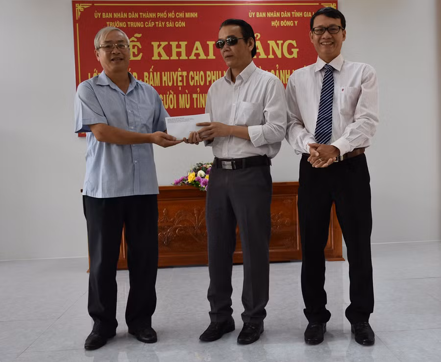 Thạc sĩ, Bác sĩ Nguyễn Khắc Thương-Hiệu trưởng Trường Trung cấp Tây Sài Gòn trao tiền hỗ trợ cho các học viên của Hội người mù tỉnh. Ảnh: Hà Phương