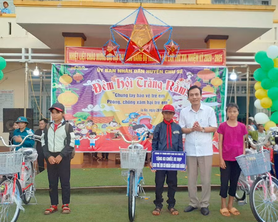 Ông Vương Đức Thông –Chủ tịch công đoàn Công ty TNHHMTV cao su Chư Sê tặng xe đạp cho học sinh xã Ia Ko. Ảnh: Hoàng Viên