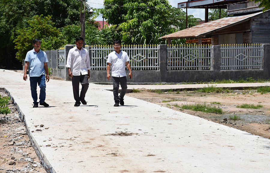  Ông Ksor Thuir (giữa) vận động người dân tự nguyện đóng góp kinh phí làm đường giúp bộ mặt nông thôn ngày càng khởi sắc. Ảnh: M.T
