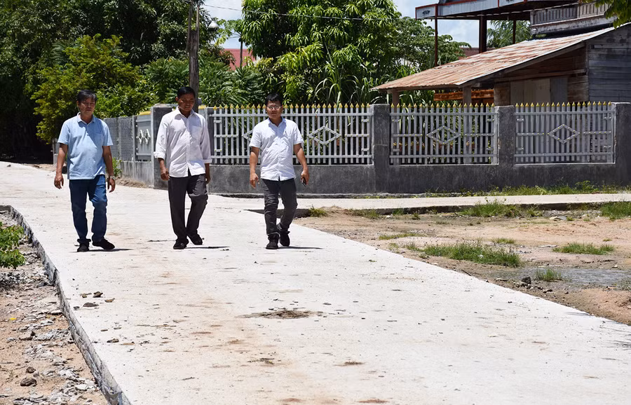  Ông Ksor Thuir (giữa) vận động người dân tự nguyện đóng góp kinh phí làm đường giúp bộ mặt nông thôn ngày càng khởi sắc. Ảnh: M.T