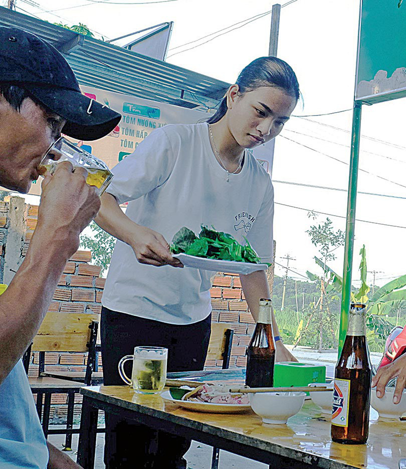 Sau khi lo cơm nước cho mẹ và chị xong, Tùng đi phụ ở quán ăn