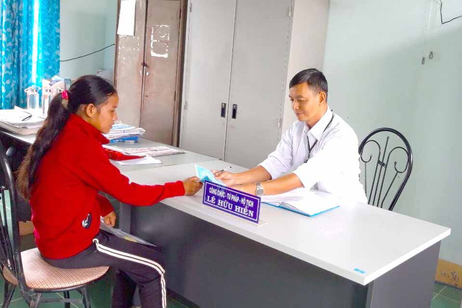 Anh Lê Hữu Hiền (bên phải), công chức Tư pháp-Hộ tịch (xã Yang Bắc, huyện Đak Pơ) hướng dẫn người dân làm giấy tờ hộ tịch. Ảnh: Ngọc Minh